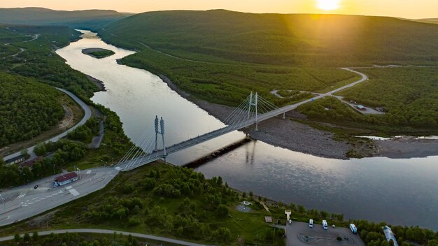 Foto el puente sami y el río teno en la hora dorada de verano en utsjoki