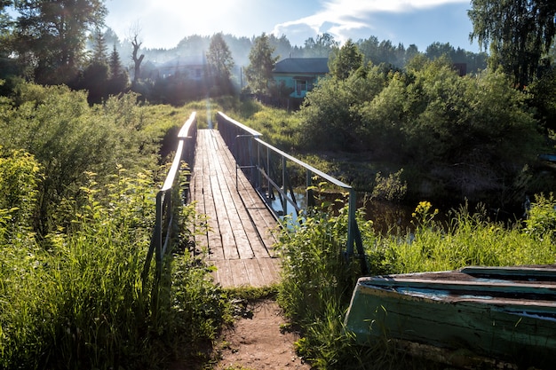 Un puente sobre un pequeño río en el pueblo de los rayos del sol.