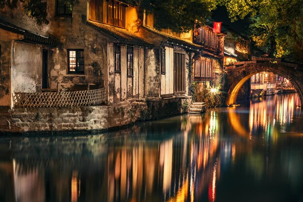 Foto puente sobre el río en la ciudad por la noche