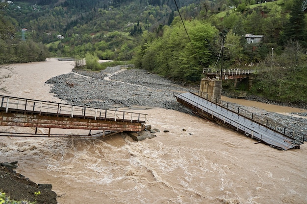 Un puente sobre un río de montaña destruido por el agua.