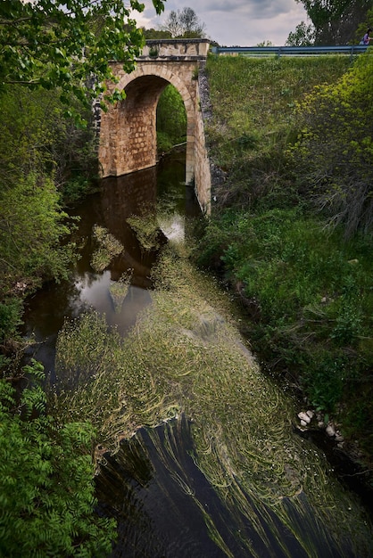 Un puente sobre un río con un puente al fondo