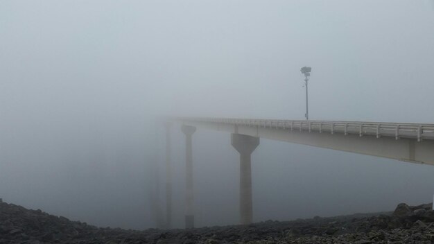 Foto puente sobre el río durante el tiempo de niebla