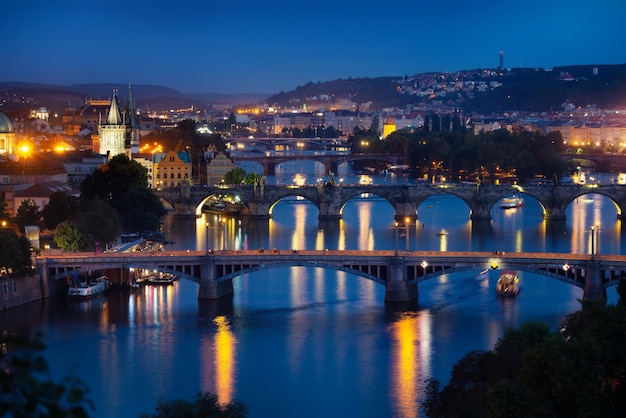 Puentes iluminados en Praga sobre el río Vltava al atardecer