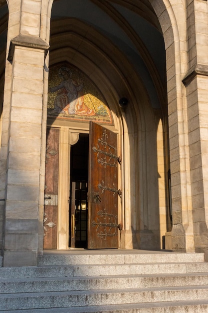 Puerta abierta a la iglesia católica medieval. Exterior de la catedral gótica. Entrada abierta de la iglesia.