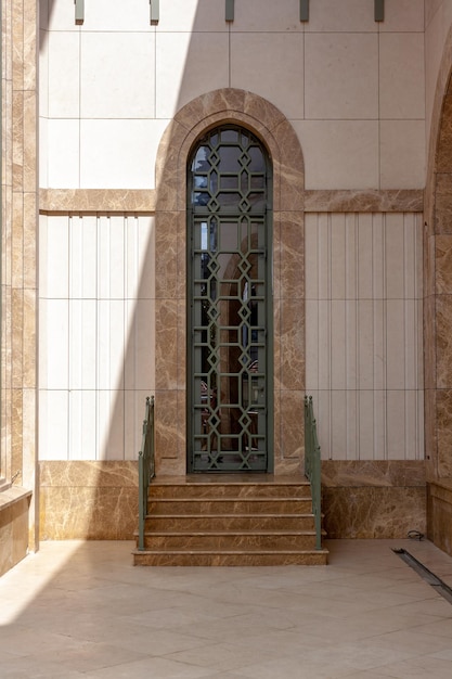 Puerta alta con escalinata al templo musulmán. Paredes y suelo de mármol. Foto vertical.