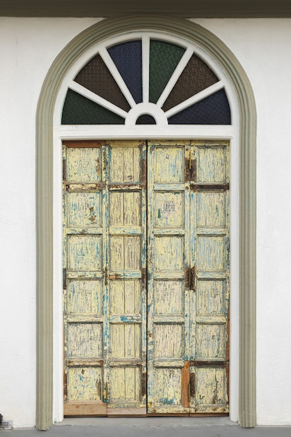 Foto puerta antigua en una pared de ladrillos tonos pastel
