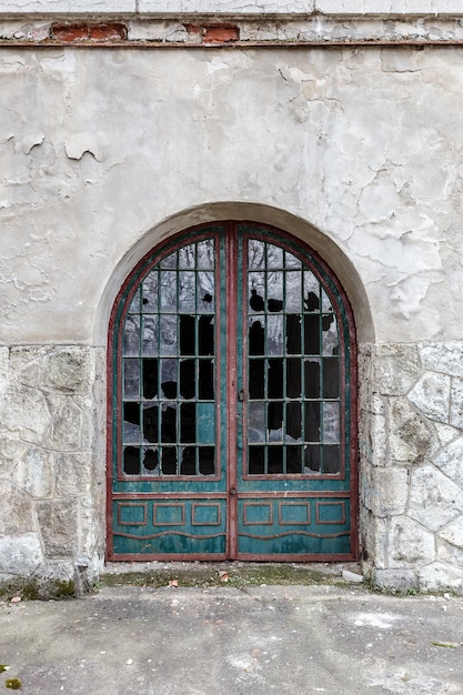 Foto puerta antigua con ventanas rotas