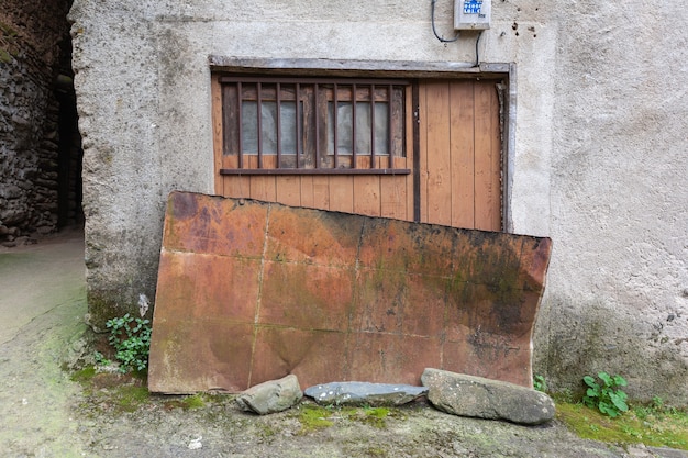 La puerta de un antiguo almacén o bloque cubierto con una hoja de metal oxidada a las inclemencias del tiempo