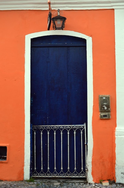 Foto puerta azul cerrada en la pared naranja