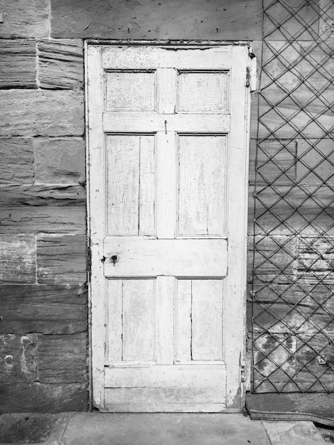 Una puerta blanca y desgastada en una pared de piedra