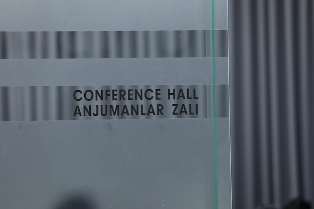 Una puerta de cristal con una sala de conferencias y anjaman zazi.