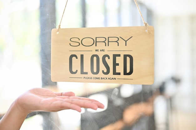 La puerta delantera de una cafetería o restaurante con un cartel de cierre