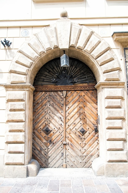 Puerta de entrada en arco de piedra en cracovia, polonia en el fondo de la pared de la fachada. Arquitectura, estructura, concepto de diseño exterior