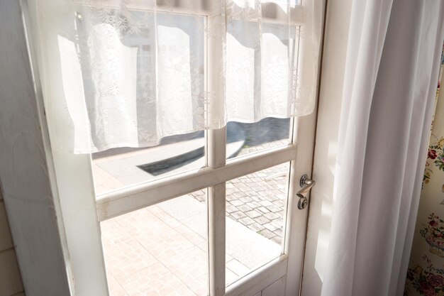 La puerta de entrada de la casa desde el interior de las cortinas y la luz del sol salen a la calle para entrar en una nueva vida