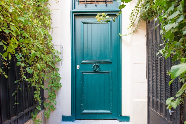 Puerta de entrada a casa con porche y plantas verdes.