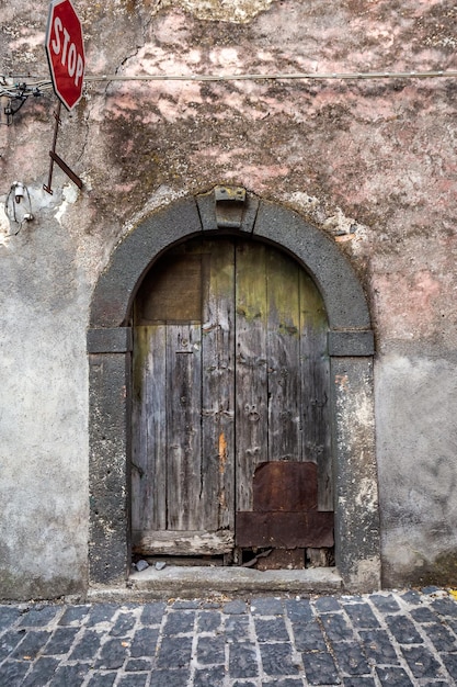 Puerta de entrada de madera antigua en la fachada del antiguo edificio barroco en la arquitectura tradicional de Catania, Sicilia, Italia.