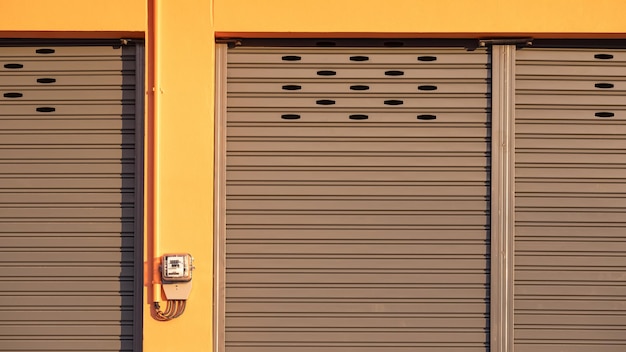 Foto puerta de entrada de la tienda de alquiler con contador eléctrico en la pared del edificio de hormigón