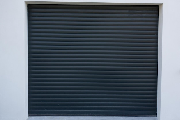 Puerta de garaje enrollable automática acceso al garaje de la casa para un camión con puerta gris oscuro