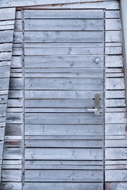 Puerta gris de madera envejecida de la cabaña en backcountry