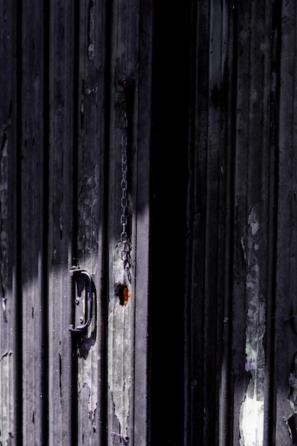 Puerta grunge oscura de un cobertizo abandonado entreabierta