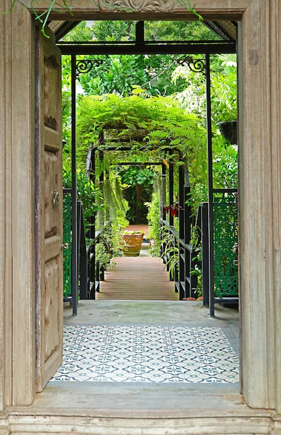 La puerta de madera se abre al jardín tropical