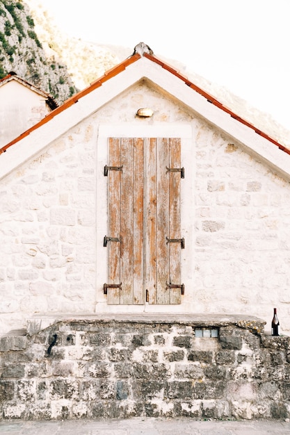 Foto puerta de madera antigua al ático en una pared blanca con techo naranja