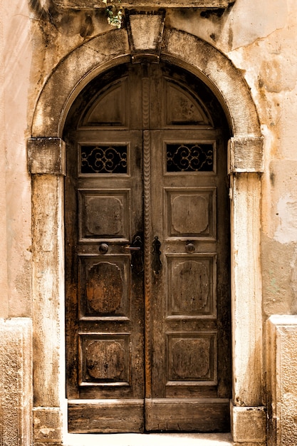 Puerta de madera antigua con cerradura en el antiguo muro de piedra. Foto tonificada.