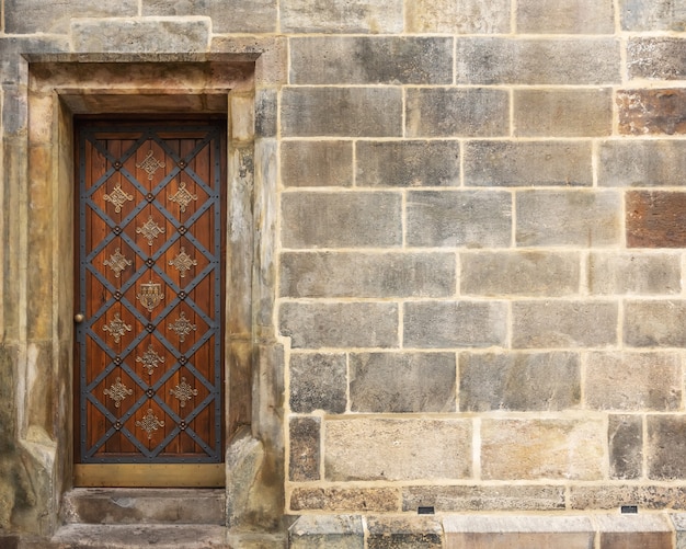 Puerta de madera antigua en la escena del muro de piedra