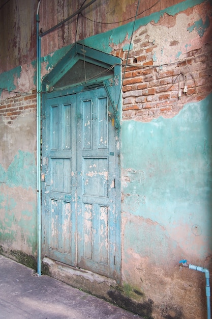 Puerta de madera azul y pared antigua