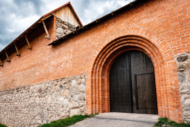 Puerta de madera en el castillo de ladrillos rojos.