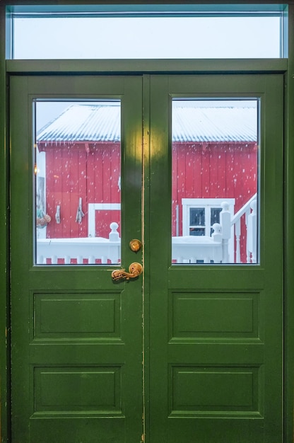 Puerta de madera dura verde cerrada con nevadas