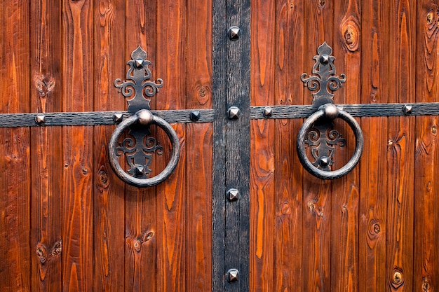 Foto puerta de madera con elementos de hierro forjado de cerca.