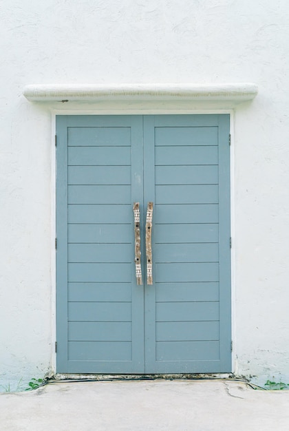 puerta de madera gris con pared blanca