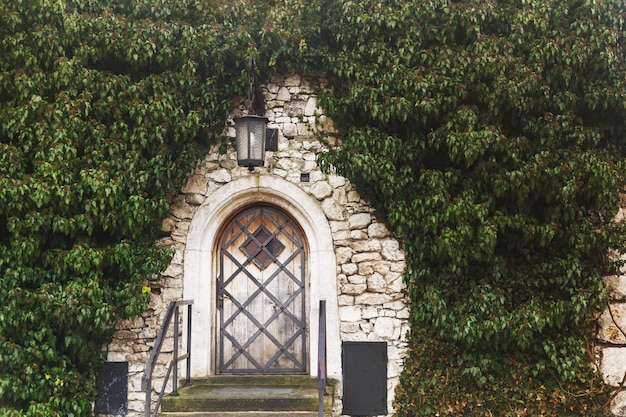 La puerta de madera en muro de piedra del antiguo castillo medieval.