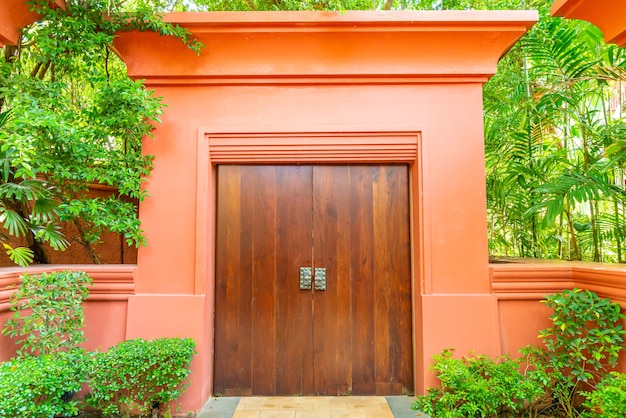 puerta de madera con pared y árbol