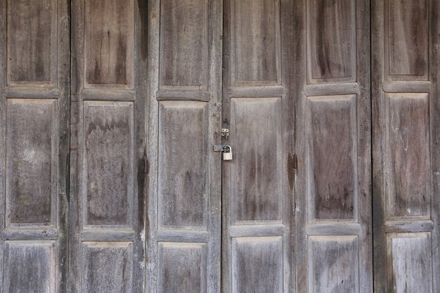 La puerta de madera vieja que cerraduras se cerró para la seguridad en concepto de presentar en su trabajo.