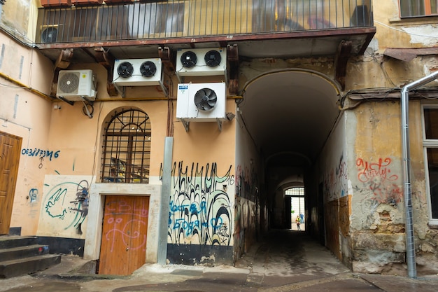 Una puerta en mal estado. Las paredes están pintadas por vándalos. Un ambiente de opresión y depresión. Lviv, Ucrania - 15.05.2019