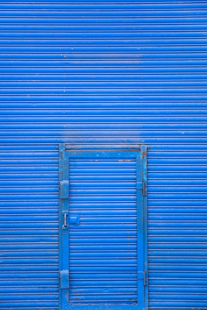 Foto puerta de metal azul en la pared azul.