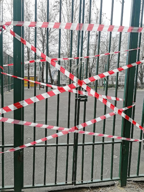 La puerta de metal se cerró con una cadena. la puerta está atada con una cinta de sujeción. áreas cerradas durante la cuarentena. Autoaislamiento del coronavirus