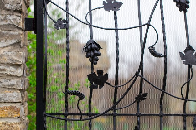 Una puerta de metal forjada cerrada que da a un sendero del jardín.