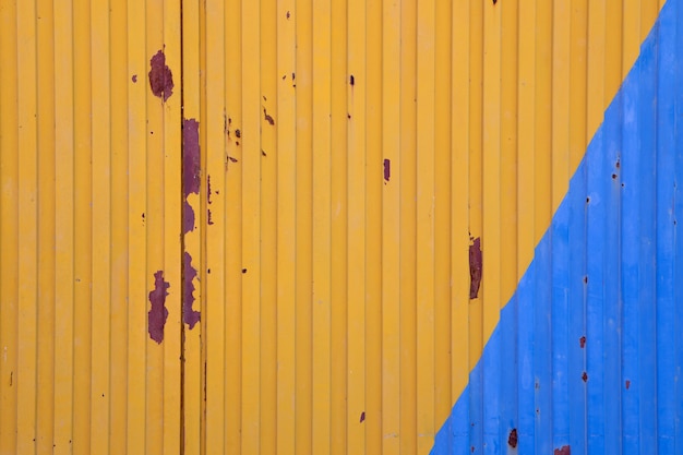 Puerta metálica pintada en azul y amarillo.