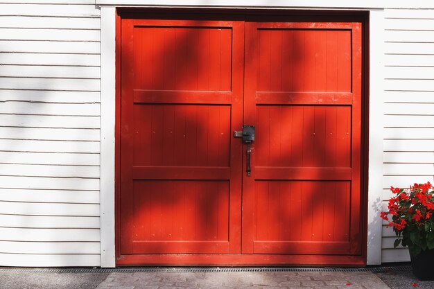 Puerta roja brillante y flores cerca