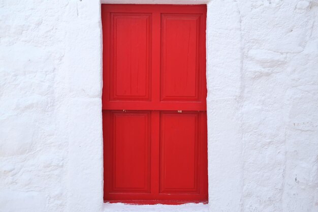 Puerta roja en la pared de piedra blanca