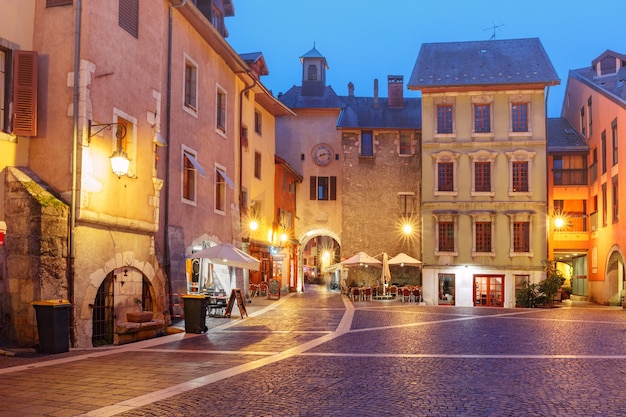 La puerta de Sainte-Claire con la torre del reloj y la Place Sainte-Claire en el casco antiguo en la noche lluviosa, Annecy, Francia