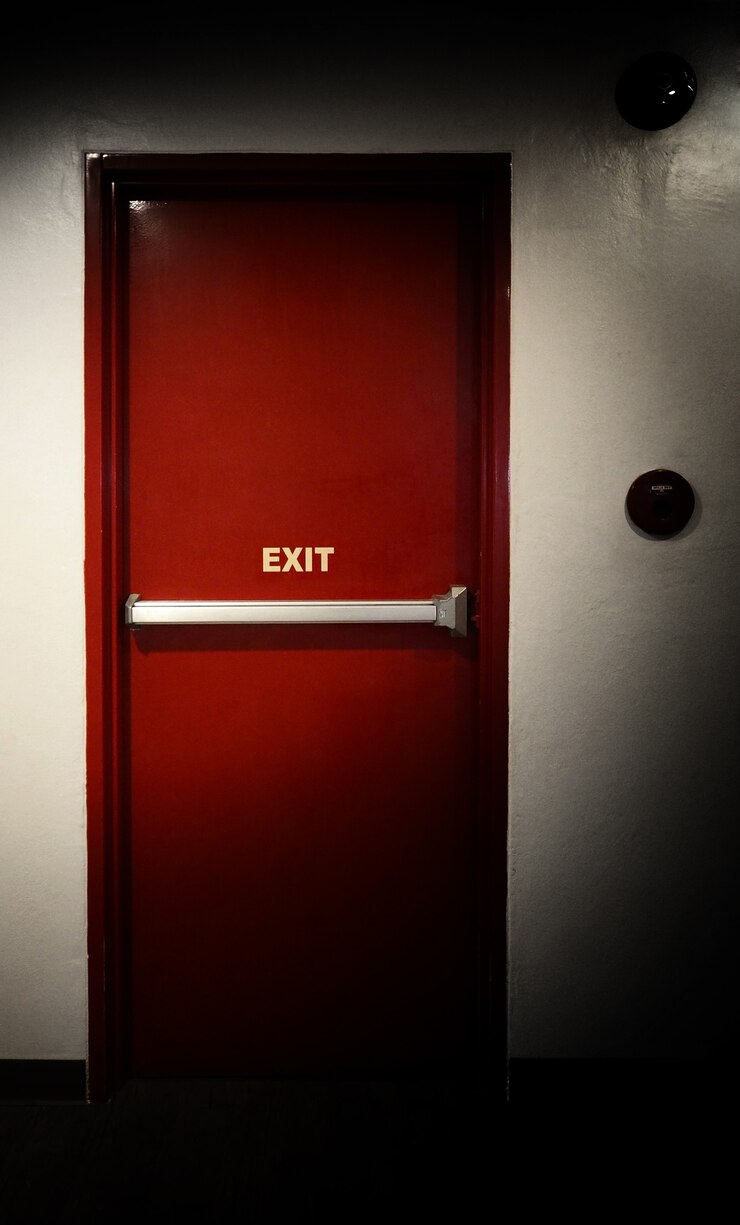 Foto puerta de salida de emergencia contra incendios y pared de color rojo y blanco en el edificio.