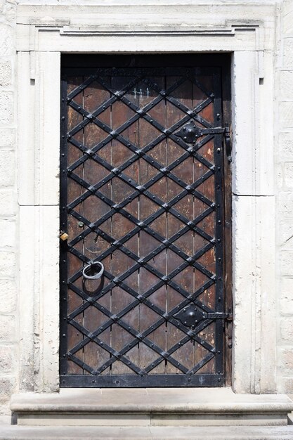 Foto puerta sólida muy antigua en la pared de piedra de ladrillo de un castillo o fortaleza del siglo x