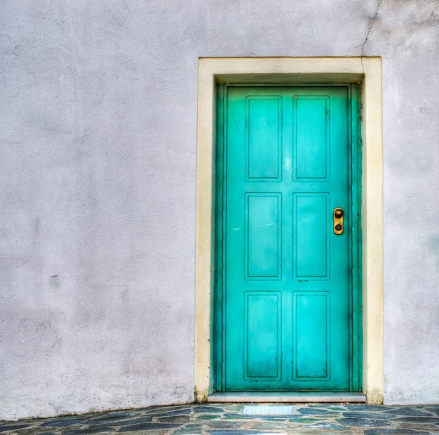 Puerta turquesa en una pared gris Rodada en Cerdeña Italia