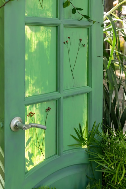 La puerta verde en el jardín, que no conduce a ninguna parte. Un elemento decorativo. Usar cosas obsoletas con una nueva calidad