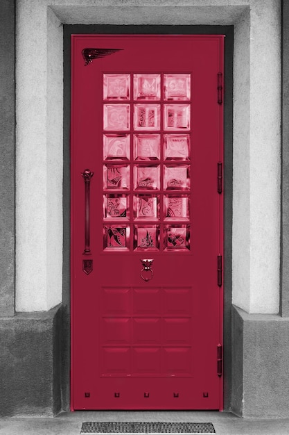 Puerta vieja en los edificios blancos. Nuevo color PANTONE 18-1750 Viva Magenta de tendencia 2023