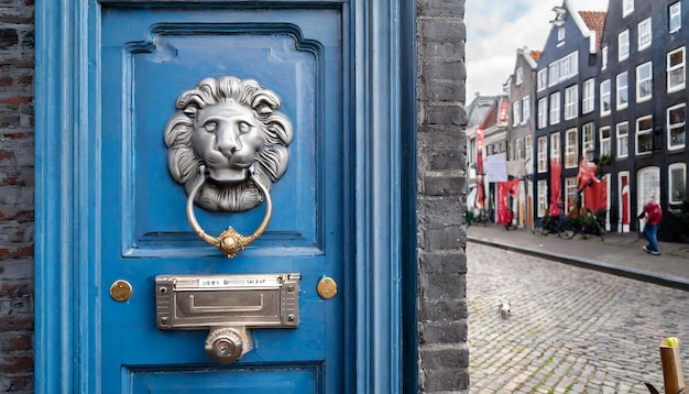 Puerta vintage azul con un golpeador en forma de una ranura de buzón de león en la puerta con publicidad